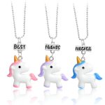 Trois colliers avec des pendentifs en forme de licorne. Les licornes sont blanches avec des crinières et des queues colorées. Les pendentifs sont attachés à des chaînes en argent.