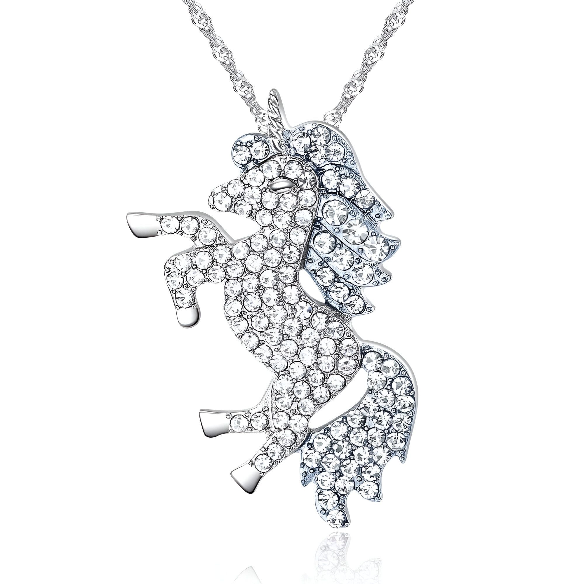 L'image montre un pendentif en forme de licorne. La licorne est debout sur ses pattes arrière et a une crinière et une queue en cristal. Le pendentif est en métal argenté.