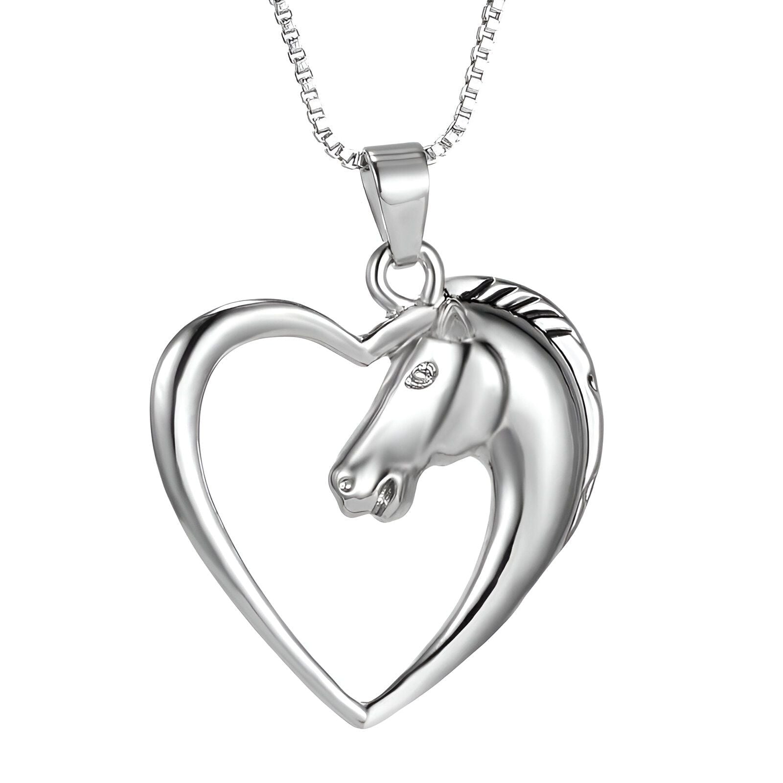 Un pendentif en forme de cœur avec un cheval à l'intérieur. Le cheval est représenté avec sa tête tournée vers la droite. Le pendentif est en métal argenté.