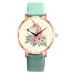 Une montre licorne avec un bracelet en cuir vert et un cadran rond avec une image de licorne et de fleurs.
